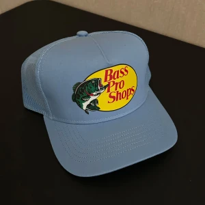 Bass Pro Shops keps - Helt ny ljusblå trucker keps från Bass Pro Shops, köpt i Miami Florida. Justerbar passform baktill. Perfekt för dig som gillar fiske eller vill ha en cool streetstyle-accessoar.