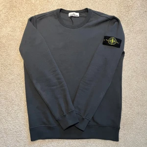 Mörkgrå sweatshirt från Stone Island - Säljer en helt ny Stone Island tröja i 10/10 skick. Mått, längd 66cm, bredd 50cm. Kan frakta eller helst mötas upp i Göteborg