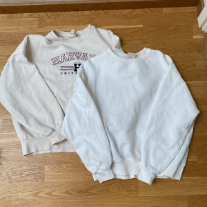 Sweatshirts  - Två  sweatshirts, en med klassiskt Harvard University-tryck i rött och svart, och en helt utan tryck. Båda har rund hals och långa ärmar med ribbade muddar. Perfekta för en avslappnad stil. Vit är i Xs. Beige är i S