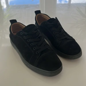 Svarta loubs med röd sula  - Säljer ett par stilrena svarta loubs med svart snörning och röd undersida. Skorna har rund tå och platt sula, samt en diskret design som passar till många outfits. Insidan är ljusbeige och materialet känns mjukt. Tvättar dom innan jag skickar iväg 