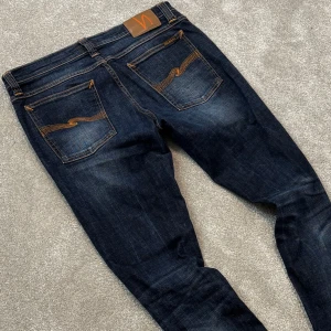 Nudie jeans - Tja! Säljer dessa feta mörkblå Nudie jeans med riktigt schysst tvätt! Jeansen är i fint skick! Size 31/34. Skriv vid funderingar!