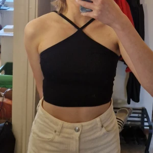 Svart croppad linnetopp från H&M  - Säljer en svart croppad linnetopp från H&M Divided i bomull i storlek S. Toppen har smala axelband som korsas framtill och ger en snygg halterneck-look. Perfekt till sommaren och enkel att matcha med olika outfits. Skriv vid frågor!✨️ Samfraktar gärna så kika in mina andra inlägg!✨️