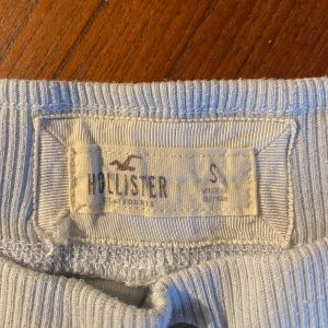 Ljusblå mjukisbyxor från Hollister - Säljer ett par supersnygga ljusblå mjukisbyxor från Hollister med ribbad midja och snörning framtill i storlek S. Byxorna är i sammet, utsvängda ben och ficka baktill, superfin passform🌷
