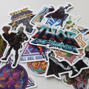 15st Thor: Love and Thunder klistermärken - Ett set med färgglada klistermärken med motiv från filmen Thor: Love and Thunder. Innehåller bilder på Thor, Jane Foster, getterna Toothgnasher och Toothgrinder, samt filmens logotyp och andra karaktärer. Perfekt för att dekorera laptop, mobil eller anteckningsbok.