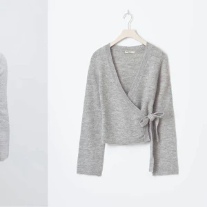 Grå omlottkofta - Säljer en stilren grå omlottkofta som är väldigt populär från Gina med knytband i midjan. Koftan har långa ärmar och är perfekt för en mysig och elegant look.