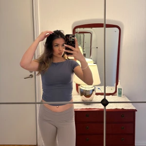 Mörkblå croppad t-shirt - Säljer en enkel och stilren mörkgrå, blåaktig, croppad t-shirt med rund halsringning. T-shirten har korta ärmar och är figurnära i passformen. Är köpt på Gina Tricot I och är i storlek XS. Är i helt nytt skick, inga defekter☺️😊