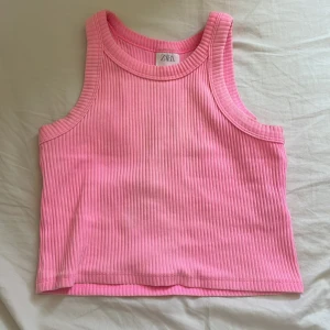 Rosa ribbad linnetopp från Zara - Säljer en söt rosa ribbad linnetopp från Zara. Toppen är ärmlös med rund halsringning och har en croppad passform. 