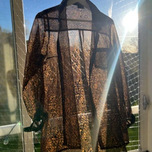Leopardmönstrad transparent skjorta från JC - Säljer en transparent skjorta från JC i storlek M med leopardmönster. Skjortan har knappar framtill och långa ärmar. Perfekt för dig som vill sticka ut med en cool och trendig look. Materialet är lätt och luftigt, vilket gör den bekväm att bära. Funkar både till fest eller stranden!
