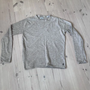 Stickad tröja - En stilren beige stickad tröja från Jack & Jones. Tröjan är i gott skick då den är lite använd. Jag stryker den innan den skickas såklart! Stl står xs men jag skulle mer säga att den är s. Hör av dig vid minsta fundering!🔥💥