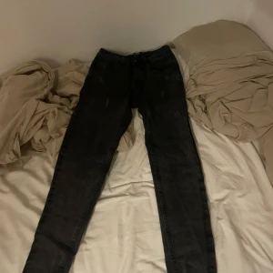 Svarta jeans från Hugo Boss - Säljer ett par svarta jeans från Hugo Boss med röda kontrastsömmar. Klassisk femficksmodell och normal passform. Perfekta för dig som vill ha stilrena och snygga jeans med en exklusiv känsla.