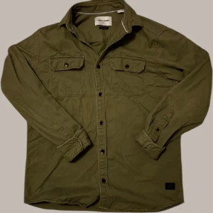 Grön Overshirt  - Säljer denna feta övershirt från Jack & Jones i storlek M🤝 passar perfekt nu till våren och sommaren eftersom den skyddar bra mot vind och är skön att ha på sig även i varma väder💯