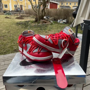 Nike Dunk Low Off-White University Red - Hej! Säljer ett par Nike dunk x Off-white skor. Köpta på Stock X, både orginal lådan och kvitto finns. Original skohorn skickas också med. Skorna är i bra skick bortom lite smutts på sulan, vilket man ser i bilderna. Föredrar hämtning i Umeå, men kan givetvis skickas vid behov!😁