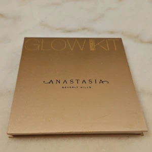 Glow Kit Sun Dipped highlighterpalett från Anastasia Beverly Hills - Glow Kit Sun Dipped highlighterpalett med fyra nyanser: Bronzed, Summer, Tourmaline och Moonstone. Paletten har en lyxig guldig förpackning och innehåller skimrande puderhighlighters i varma och neutrala toner.
