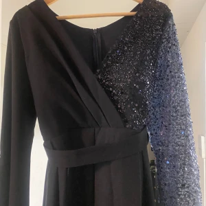 Marinblå festklänning med paljettärm -  Säljer en superfin och modest klänning i marinblått, perfekt för bal, bröllop eller andra festliga tillfällen. Använd endast en gång – i nyskick!