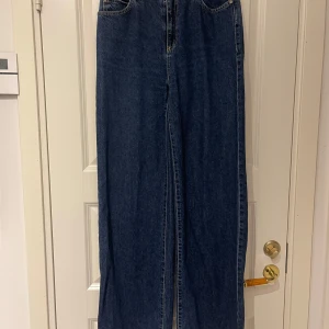 Mörkblå wide leg jeans - Säljer ett par blå jeans från Trendyol, köpta på NAKD, med wide leg-passform. Lite slitna längst ner på ena benet.