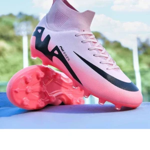 Rosa och svarta fotbollsskor med snörning - Säljer ett par snygga fotbollsskor i rosa med svarta detaljer och snörning. Skorna har högre skaft och plös för extra stöd samt dobbar för spel på gräs. Perfekta för dig som vill sticka ut på planen! Helt nya 