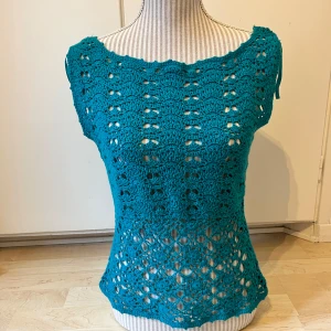 Vintage topp  - Säljer en turkos virkad topp från H&M i storlek M. Toppen har ett vackert virkat mönster framtill och ribbad baksida. 