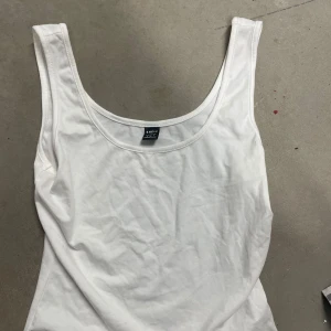 Vit linnetopp från SHEIN - Säljer en enkel och stilren vit linnetopp från SHEIN. Toppen har rund halsringning och ärmlös design, perfekt för varma dagar eller som lager under andra plagg.