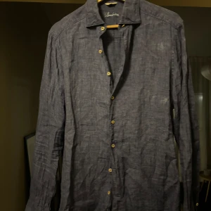 Mörkblå linneskjorta från Stenströms - Stilren mörkblå skjorta i linne från Stenströms. Nypris 1699. I bra skick, endast använd varsamt under en sommar. Säljer pga för liten för mig.