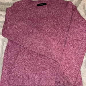 Rosa, Lila stickad tröja - Mysig rosa stickad tröja med rund halsringning och långa ärmar. Perfekt för kyliga dagar och enkel att matcha med jeans eller kjol. Tröjan har en mjuk känsla och en klassisk passform.