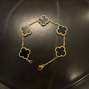 En Van cleef and arpels liknande armband  - Säljer min van cleef and arpels liknande armband som är guldplaterade samt är varje klövers färg baserade på en svart sten! Köptes för 1000kr säljes för 600kr eftersom den har använts mycket men är i ny skick och kan därefter sänka priset mer!