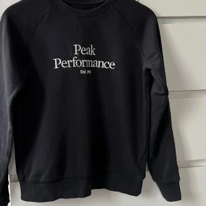 Svart sweatshirt från Peak Performance - Svart sweatshirt från Peak Performance med tryck som knappt är använd.