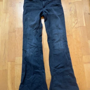 Svarta bootcut jeans från weekday - Säljer ett par svarta jeans från weekday med bootcut-modell. Jeansen har klassisk femficksdesign, gylf med dragkedja och knapp samt tydlig Cheap Monday-logga bak i midjan. Perfekta för dig som gillar en lite vidare passform nertill.