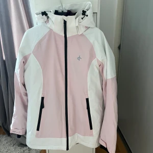 Ljusrosa och vit skidjacka med huva - Säljer en ljusrosa och vit skidjacka från Everest . 