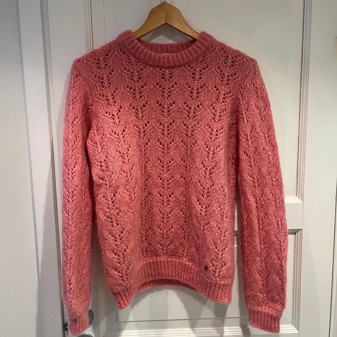 Rosa stickad tröja med spetsmönster