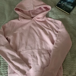 Ljusrosa hoodie från GANT - Skriv om ni vill se hur den ser ut på!!💗💗Säljer en ljusrosa hoodie från GANT med klassisk logga broderad på bröstet. Tröjan har huva, magficka och långa armar!💕