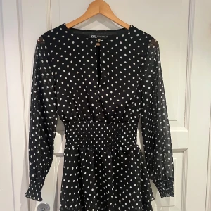 Svart prickig klänning från Zara - Supersöt svart klänning med vita prickar från Zara. Knappt använd, och passar perfekt nu till vår och sommar🖤