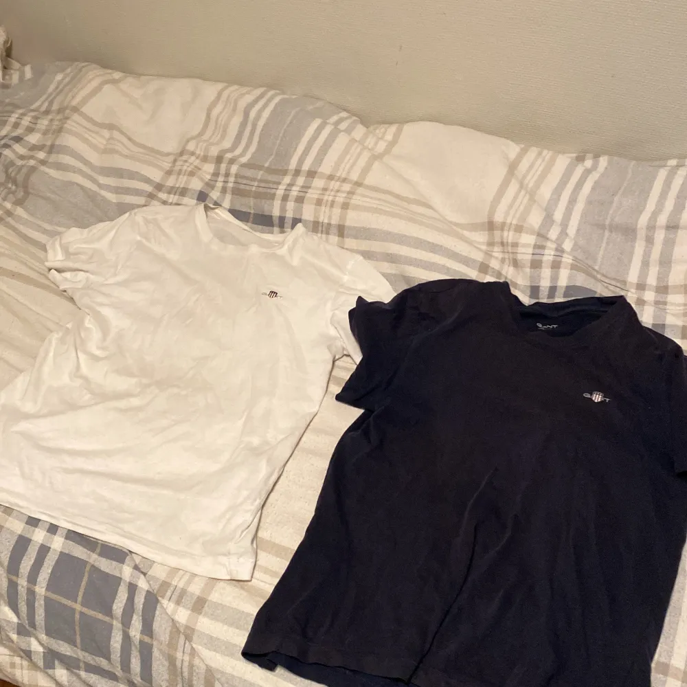 Säljer två stilrena t-shirts från GANT i storlek 146/152. En är vit och en är mörkblå, båda med liten broderad logga på bröstet. Perfekta basplagg med normal passform och korta ärmar. Sköna och enkla att matcha till det mesta. Nypris för båda tillsammans: 449. 300 för båda och en för 150kr. Båda två är från kidsbrandstore.. T-paidat.