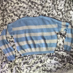 Blåvit randig stickad tröja från ONLY - Säljer en söt stickad tröja från ONLY i storlek 134-140. Tröjan har breda blå och vita ränder, rund halsringning och långa ärmar med ribbade muddar. Perfekt för dig som gillar mysiga och stilrena plagg! Den är blå och vit!