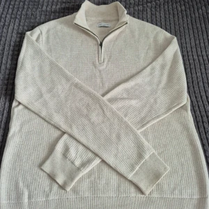These Glory Days half zip - Säljer en beige stickad tröja från These Glory Days i storlek L men skullepassa M. Tröjan har halv dragkedja framtill, hög krage och ribbade muddar. Perfekt för lager-på-lager och enkel att matcha med olika outfits. Köpte för 1000kr 