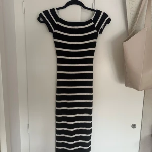 Svartvit randig ribbad klänning från Pull&Bear! - Säljer en svart och vit ribbad klänning från Pull&Bear i storlek XS. Klänningen har korta ärmar, rund halsringning och ett tight passform. Skriv vid intresse eller funderingar!❤️