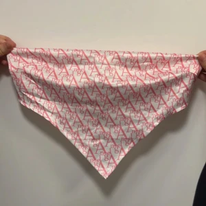 Vit och rosa topp - Säljer en snygg topp i vitt med rosa logotypmönster över hela tyget. Inga armar bara tyg vid bysten och öppen rygg. 