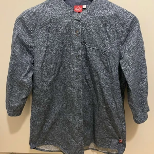 Mönstrad blå skjorta från Segers - Säljer en blå skjorta från Segers med diskret mönster och knappar framtill. 