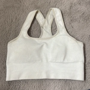 Ljus beige ribbad sport-bh från TriDri - Säljer en ljus beige ribbad sport-bh från TriDri. Tillverkad i en mjuk och stretchig blandning av polyamid, polyester och elastan. Perfekt för träning och ger bra stöd. Enkel och stilren design. Storlek S, pris kan diskuteras🌸