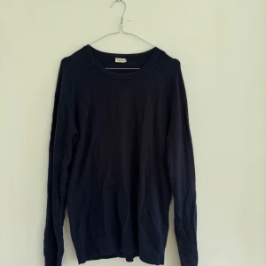 Svart långärmad tröja från Filippa K - En stilren svart långärmad tröja från Filippa K i storlek S. Tröjan har en klassisk rund halsringning och är tillverkad i ett mjukt material som passar perfekt till många olika outfits. Sparsamt använd 