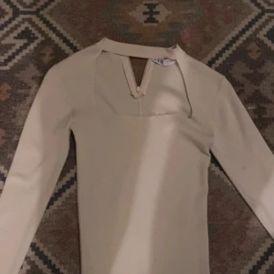 Beige långärmad klänning med öppen rygg från NA-KD - Trendig kräm vit topp från zara med lång ärm och  öppen fram till. Perfekt för dig som gillar stilrena och moderna plagg. passar M också💞