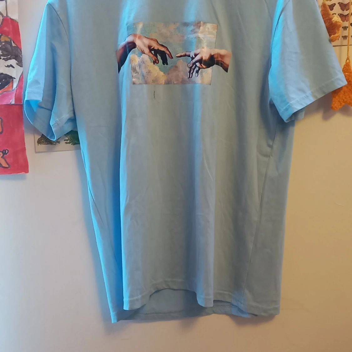 Ljusblå t-shirt med konstmotiv