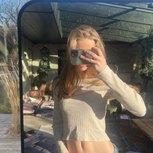 Beige ribbad offshoulder-tröja från Gina Tricot - Säljer en beige ribbad offshoulder-tröja från Gina Tricot. Tröjan har långa ärmar och sitter figurnära med en bred krage som vilar över axlarna. Perfekt basic tröja.