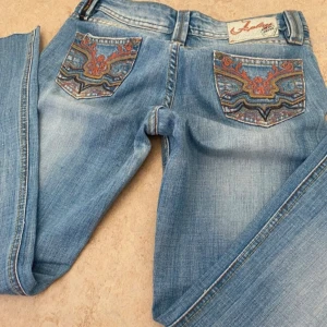 Low waist jeans - Säljer ett par ljusblå jeans med snygga broderade detaljer på bakfickorna. Köpte på karlaplan loppisen men de passade tyvärr inte mig så säljer vidare!💕 står ingen storlek men skulle gissa på runt medium.