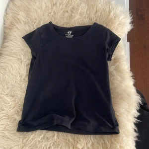 Svart kortärmad t-shirt från H&M - Jag har andvänt den när jag är 15 år så man måste inte vara 10 år den blir bara tigtare om du är äldre. En enkel svart t-shirt från H&M Basic i ekologisk bomull. Modellen har rund halsringning och korta ärmar, perfekt för en clean och stilren look.