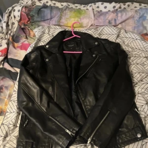 Svart skinnjacka från The Black Label Collection - Säljer en svart skinnjacka från The Black Label Collection i storlek M. Jackan kan användas som en racer jacka.
