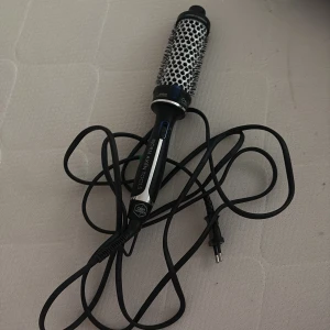 Björn Axén Tools varmluftsborste - En svart och silver varmluftsborste från Björn Axén Tools med rund borste och keramisk yta. Perfekt för att styla och forma håret med volym. Borsten har ett ergonomiskt handtag och lång sladd för enkel användning. OBS! Förpackning kommer inte med. Storlek 38mm