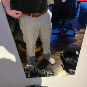 Ljusgrå linnebyxor/med normal passform - Snygga ljusgrå linnebyxor med klassisk rak passform. Sköna och luftiga, perfekta för varmare dagar. Sitter bra runt benen men lite för stora runt midjan för min del så skärp behövs ofta och då fungerar de fint o sitter bra!