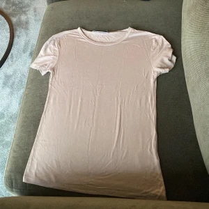 Beige t-shirt från 157 - En enkel och stilren beige t-shirt från 157 i storlek XS. T-shirten har rund halsringning och korta ärmar, perfekt för en avslappnad look. Tillverkad i mjukt material som känns skönt mot huden.
