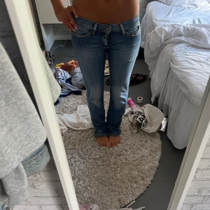 Lågmidjade blå jeans från Gang - Säljer ett par snygga lågmidjade jeans från Gang i klassisk blå tvätt. Jeansen har raka/bootcut ben. Inga te Ken på användning förutom att dragkedjan har hoppat men väldigt lätt att lösa. Storlek står inte men jag är en 27-28 i jeans och skulle säga att dessa är 27-26 i storlek