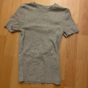 Grå basic t-shirt från Bik bok - Enkel grå t-shirt i mjuk bomull med rund hals och korta ärmar. Perfekt för en clean och avslappnad stil. Passar till allt och är ett måste i garderoben.